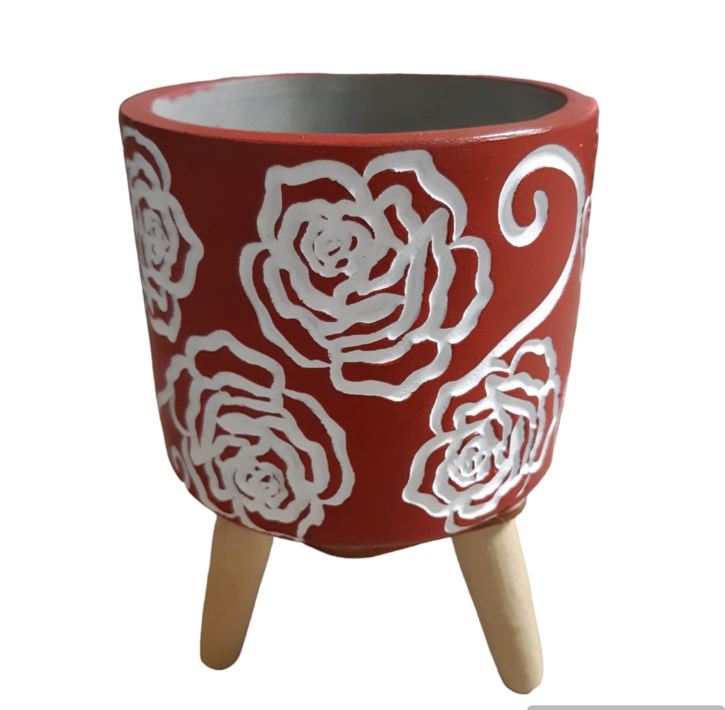 Vaso in cemento rosso con rose bianche su treppiede in legno