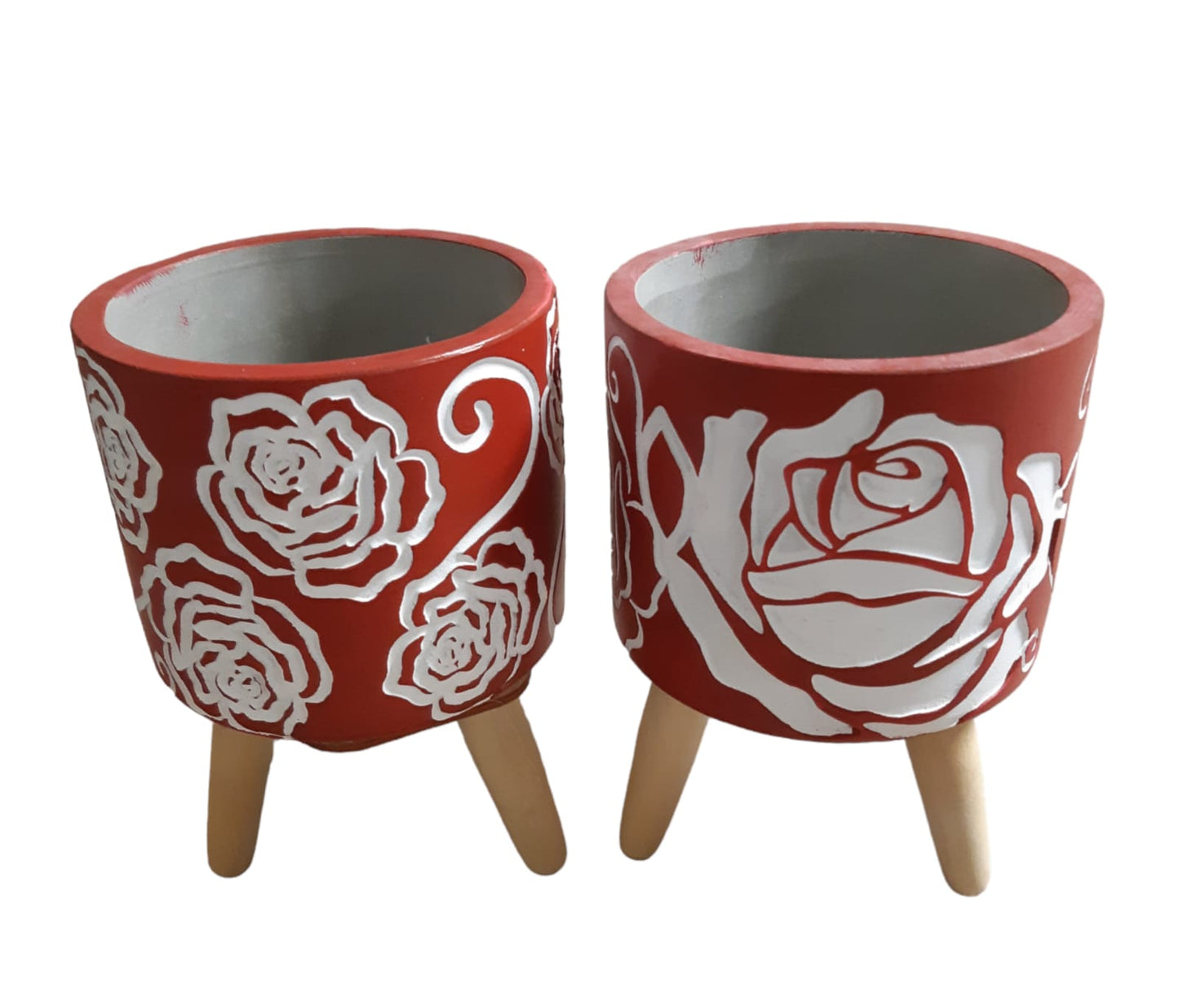 Vaso in cemento rosso con rose bianche su treppiede in legno